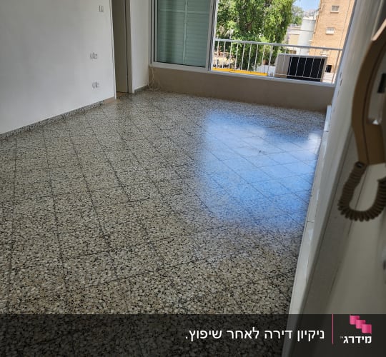 חדר ריק עם רצפת אריחים וחלון גדול